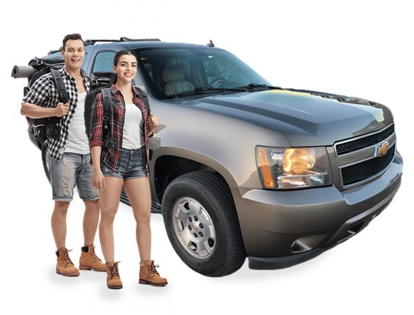 Photo of two hikers in front of an SUV.